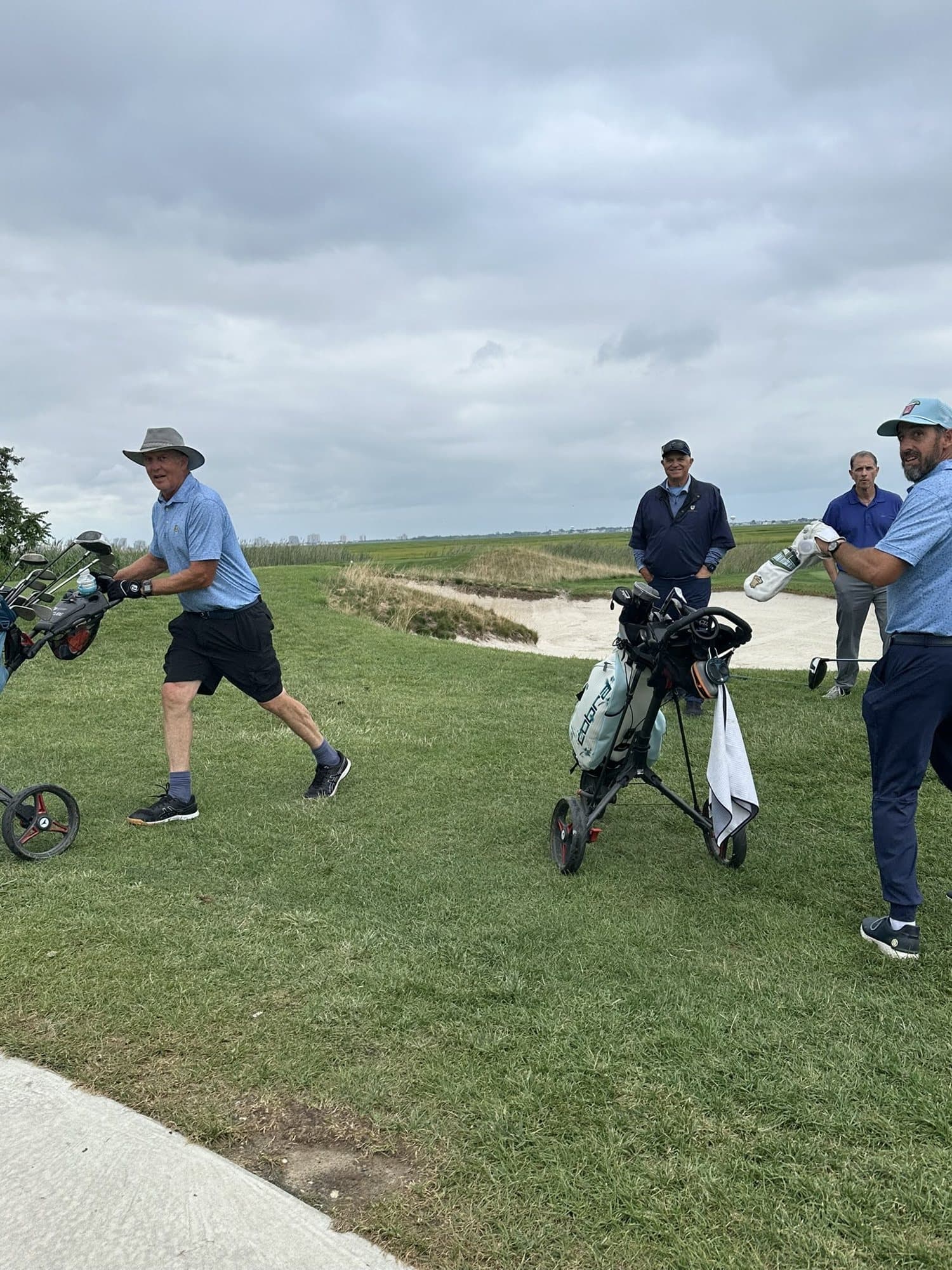 Golfers walking off the tee with push carts