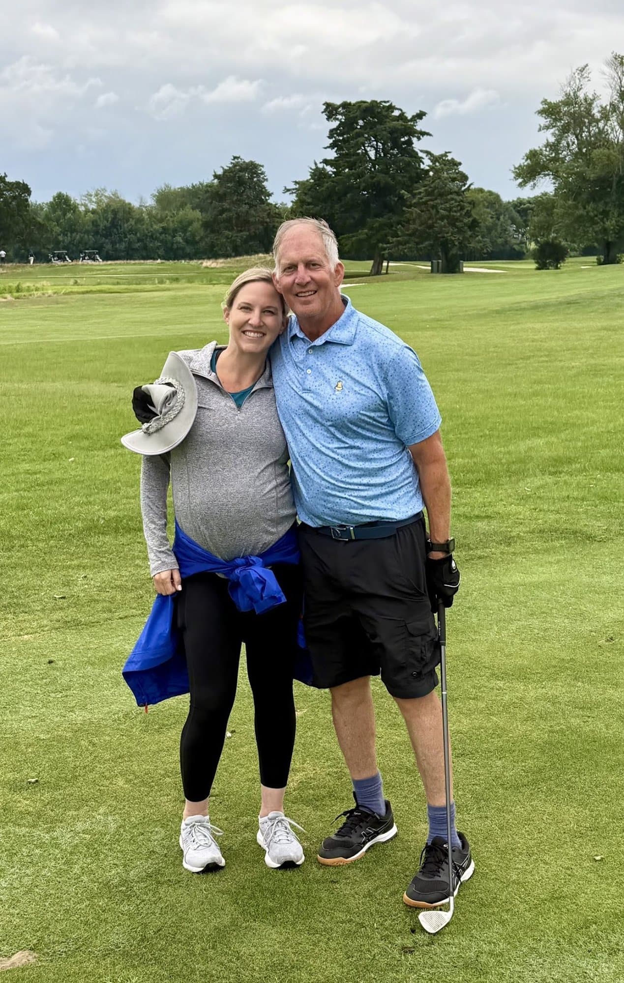 A supporter and a golfer smiling on the course